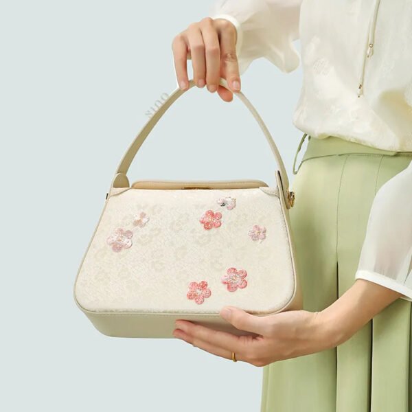モデル手持ちプラム・ブロッサム・バッグ model-hand-holding-plum-blossom-bag